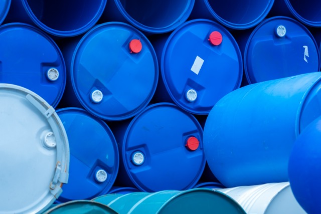 Old chemical barrels. Empty blue chemical drums stack. Steel and plastic oil tank. Toxic waste warehouse. Hazard chemical barrel. Industrial waste in drum. Hazard waste storage in factory.